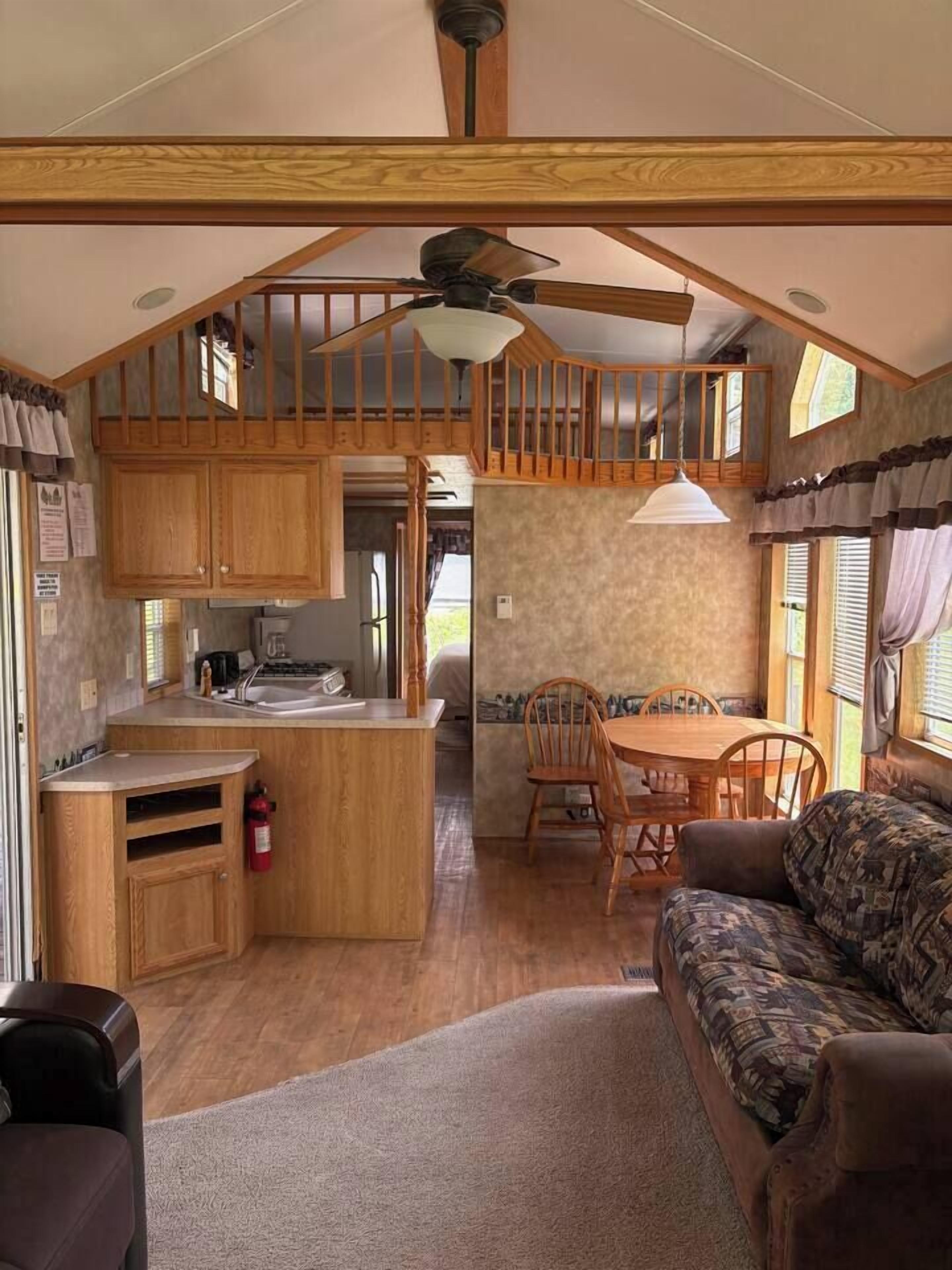 A cozy RV interior with a kitchenette, dining area, and a sofa.