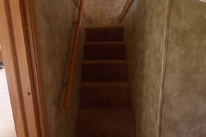 A narrow stairway with wooden handrails and carpeted steps leading to a landing. - Vintage Voyager on Black Lake (Hammond)
