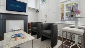 Un salon moderne avec une cheminée, un téléviseur et des sièges confortables.