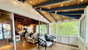 A cozy cabin interior with a wooden deck, a dining area, and a kitchen. - Seaside Cabin Retreat – Breathtaking Views & Ocean Access (Harpswell)