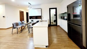 A modern kitchen with a built-in island, stainless steel appliances, and a dining area with a table and chairs.