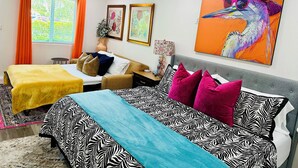 A hotel room with two beds, a large painting of a bird, and a window with curtains. - Chic Casita with AC, WiFi in peaceful Coachella (Coachella)