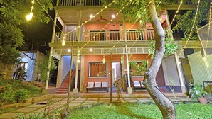 Ein zweistöckiges Gebäude mit Balkon, Außenbereich und Lichterketten.