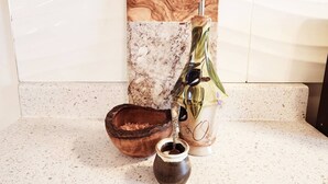 A wooden tray with a handle, a ceramic mug, and a ceramic pot with a spoon.