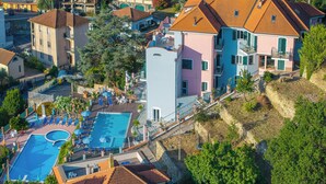 An aerial view of a residential area with a swimming pool, multiple houses, and a hillside. - Seaview Pool Retreat - B28, Andora, Italy (Andora)