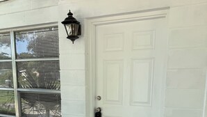 A white door with a keyhole and a doorbell.