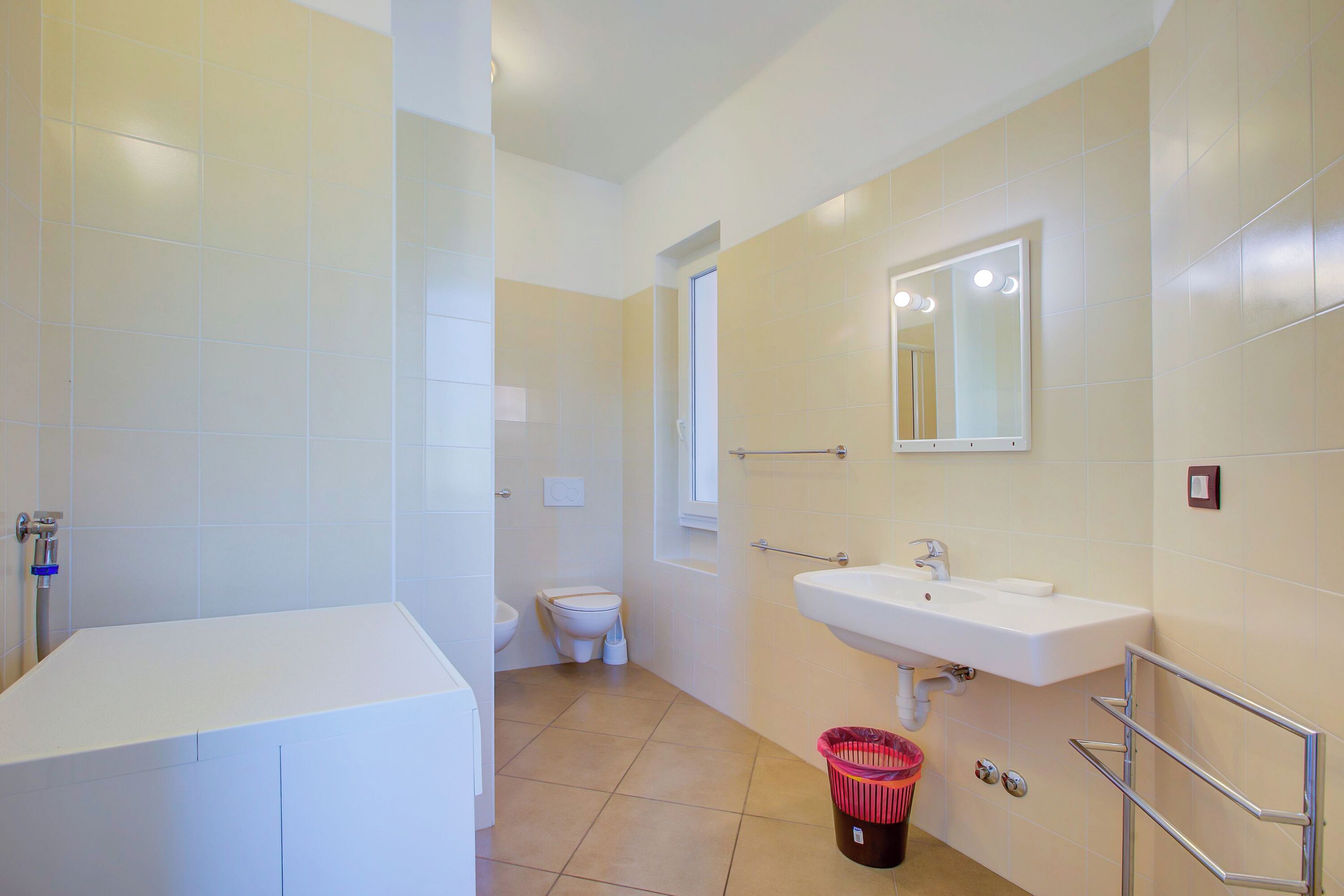 Une salle de bain avec une baignoire, des toilettes, un lavabo et un miroir.