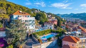A residential area with a swimming pool, houses, and a bridge in the background. - Seaview Pool Retreat - B6, Andora, Italy (Andora)