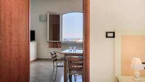 Una habitación con una mesa de comedor, sillas, un televisor y un ventanal con vistas.