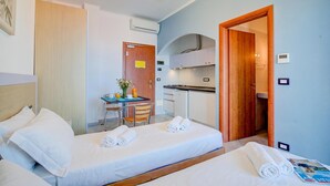 A hotel room with two beds, a kitchenette, a dining area, and a bathroom. - Seaview Pool Retreat - M8, Andora, Italy (Andora)