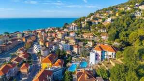 Une ville côtière avec des bâtiments, une piscine et une vue sur la mer.