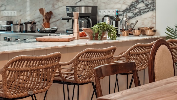 A kitchen with marble countertops, wicker chairs, and modern appliances. - Athens City Views - 4BR Luxury w/ Chef's Kitchen & Balconies (Athina)