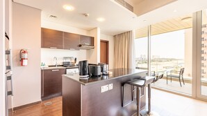 Cocina moderna con una isla central, taburetes de bar y un amplio ventanal con vista a la ciudad.