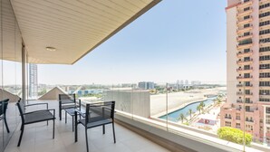 Un balcón con vista a una playa y edificios altos.