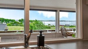 Cocina con vista a un lago y vegetación.