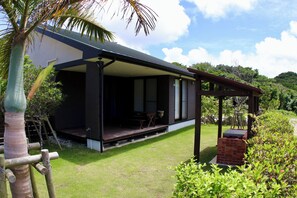 A modern house with a covered porch, a brick fireplace, and a well-maintained lawn.
