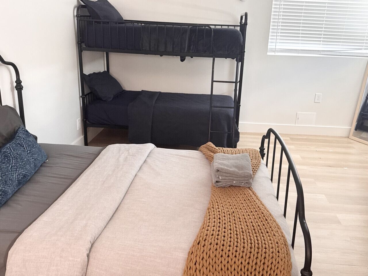 Un lit superposé avec un lit en bas et un lit simple en haut, tous les deux équipés d’oreillers et de couvertures.