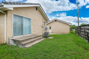 A residential building with a brick exterior, a large sliding glass door, and a satellite dish. - Dazzling East Side 3BR 2 BA Coffee/WFI/SMRT TV (Wichita)