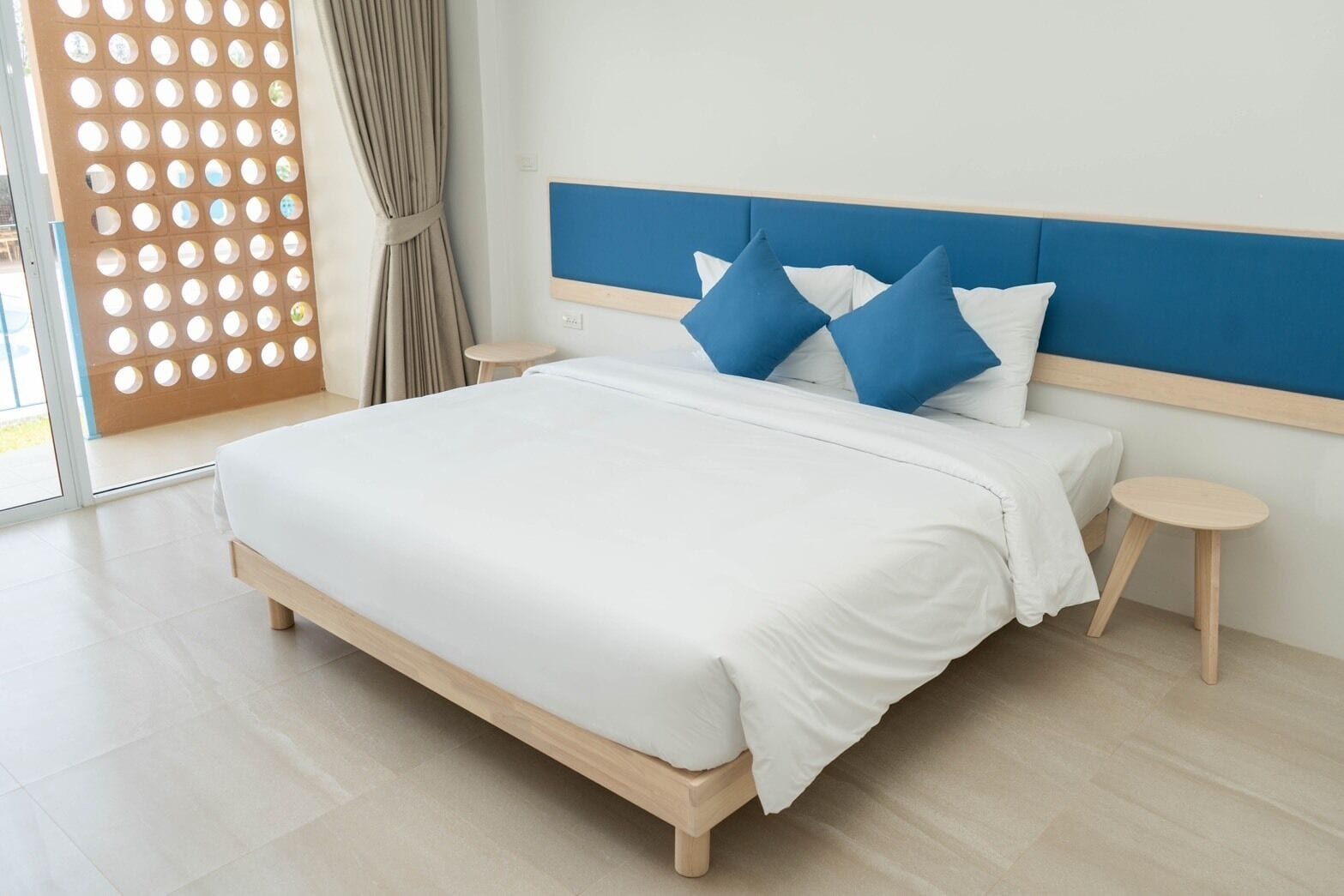 Ein modernes Schlafzimmer mit einem großen Bett, zwei Nachttischen und einer Kopfteil.