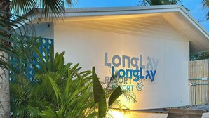 A building with a sign reading "Long Lay Resort" and a boat docked outside.