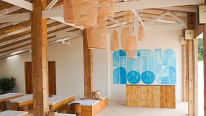 A modern spa with wooden beams, benches, and a large abstract mural.