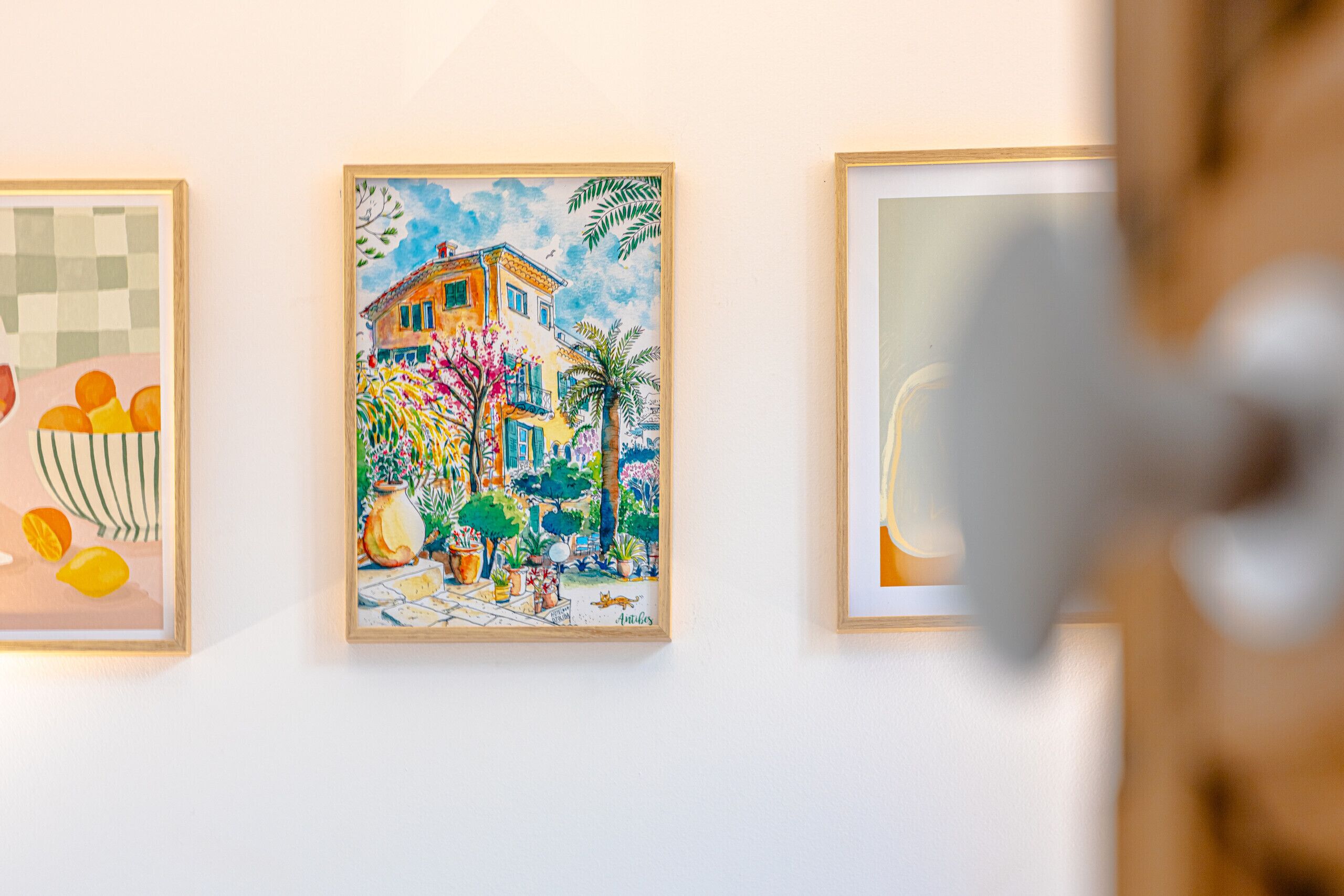 Three framed artworks on a wall.