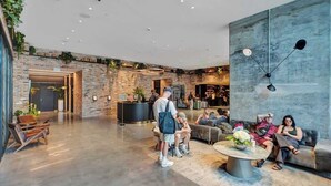 A spacious lobby with a brick wall, a reception desk, and seating areas. - Miami Lux Studio 45th floor City and Bay Views (Miami)