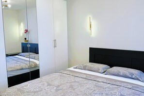 A bedroom with a bed, a wardrobe, and a mirror. - Sea view apartment Rijeka-free parking-6 people (Rijeka)