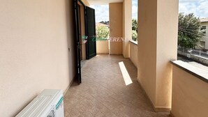 A narrow balcony with a tiled floor, beige walls, and a door with black shutters. - 5 beds with private parking space Ref. Costanza (San Vincenzo)