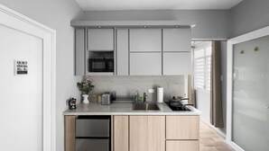Eine moderne Küche mit integriertem Mikrowellenherd, einem Edelstahl-Kühlschrank und einer Spüle.