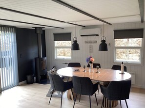 Un comedor moderno con una mesa redonda, sillas negras y una estufa negra.