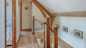 A room with wooden beams, a staircase, and framed pictures on the wall. - Y Llaethdy - UK49916 (Pen-clawdd)
