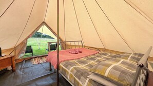 A tent with a bed, a small table, and a chair. - 1 bedroom accommodation in Abergele (Abergele)