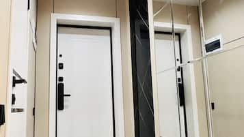 Un interior moderno con una puerta blanca, un espejo y un suelo de tonos claros.