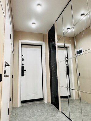 A modern interior with a white door, a mirror, and a light-colored floor. - Charming 1-bedroom apartment with AC, WiFi in Balkhash (Balkhash)