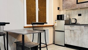 Een moderne keuken met een eetgedeelte, voorzien van een raam, inbouwapparatuur en een minimalistisch design.