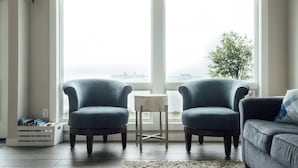 A living room with two blue armchairs, a small side table, and a gray sofa. - Park Point Oasis | On Lake Superior | Duluth (Duluth)