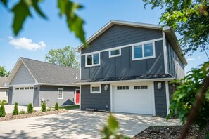 A two-story residential building with a garage, a red door, and a number '207' on the front. - Park Point Oasis | On Lake Superior | Duluth (Duluth)