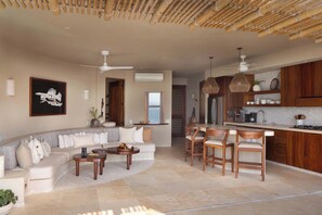 A modern living room with a sofa, coffee table, and dining area with chairs.