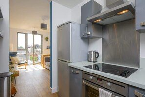 Una cocina moderna con electrodomésticos de acero inoxidable, horno empotrado y un amplio ventanal con vistas a la ciudad.