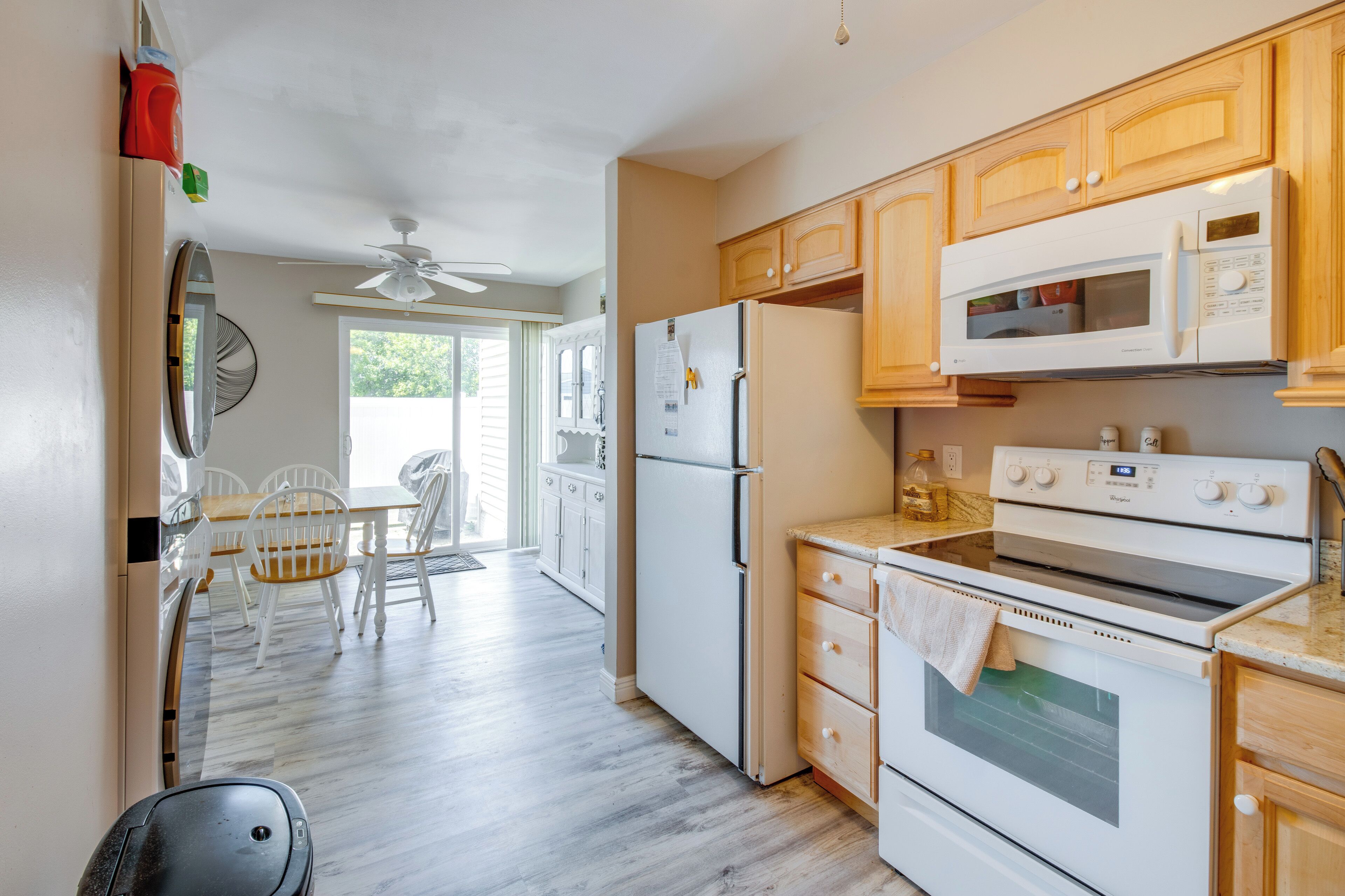 A kitchen with wooden cabinets, a refrigerator, a microwave, and an oven.