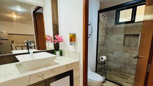 A modern bathroom with a marble sink, a glass shower enclosure, and a toilet. - Supreme Cancun Hotel Zone #72 right in the heart of the Cancun Hotel Zone. (Cancún)