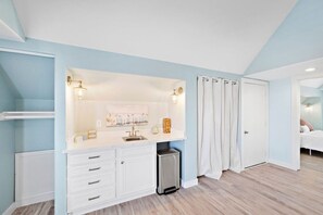 Un baño moderno con tocador blanco, lavamanos y zona de ducha.