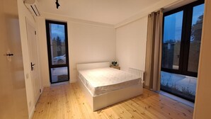 Un dormitorio con cama, ventana y puerta.