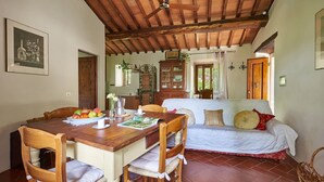 Una habitación acogedora con una mesa de comedor de madera, un sofá y un ventilador de techo.