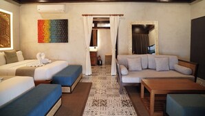 Una habitación de hotel con una cama, un sofá, una mesita y una alfombra estampada.