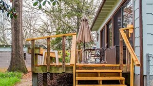 Un terrazzino in legno con una scala che conduce a una casa.