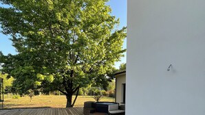 A wooden deck with a pool, a tree, and a building. - Villa with pool Pessac between Bordeaux and Bassin d'Arcachon (Pessac)
