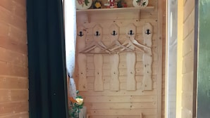 A wooden interior with a staircase, a wall-mounted coat rack, and a large vase with flowers. - Holiday Home 'Bernau13, Rechbergblick' with Mountain View, Shared Garden and Wi-Fi (Bernau im Schwarzwald)