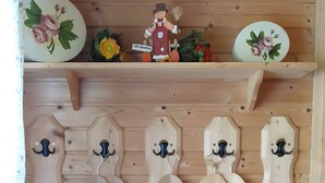 A wooden wall with a coat rack, decorative plates, and a small figurine. - Holiday Home 'Bernau13, Rechbergblick' with Mountain View, Shared Garden and Wi-Fi (Bernau im Schwarzwald)